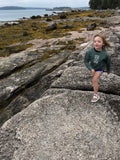 Child wearing Basil kid crew sweatshirt playing on rocky beach